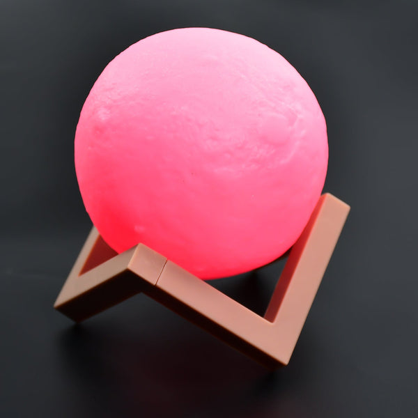 Pink moon night lamp with wooden stand for bedroom decor.